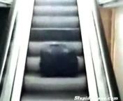 A woman rolls down the escalator, and by the looks of the guy chasing her, I&#39;d say she was rolled like a bowling ball.