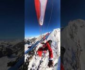 This paraglider donning a Santa Clause costume decided to fly down the snow-covered French Alps. They smoothly flew down the mountain while holding a stick in one hand and waving frequently in between with the other.