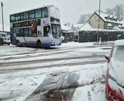 Video shows a gang of youngsters swarm behind a stranded double decker bus in Crosspool, Sheffield, stuck in the snow, to get it moving again