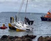 These dramatic videos show the aftermath of a sailing boat which crashed into rocks along the Cornish coast this morning.&#60;br/&#62;&#60;br/&#62;The footage shows an RNLI lifeboat approaching the sinking ship just a few metres from the rocky shore.&#60;br/&#62;&#60;br/&#62;As the crew board the boat to survey the damage, two men from the vessel can be seen onboard as it tilts into the sea in St Mawes, Cornwall.&#60;br/&#62;&#60;br/&#62;Charlotte Auger, 36, was at home with her husband when he alerted her to the crash at around 10.30 am this morning (May 5).&#60;br/&#62;&#60;br/&#62;She said: &#92;
